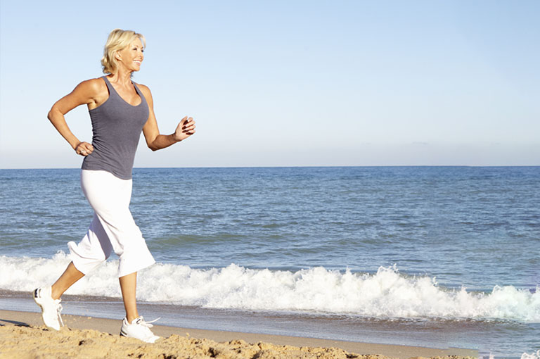 Woman in Her 40s Jogging on the Beach for Weight Loss